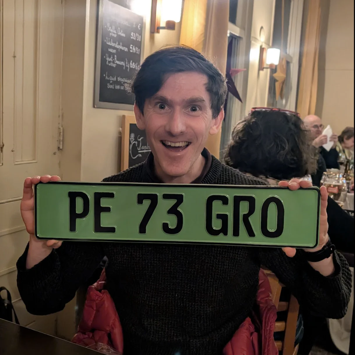 Pete Dyson, AAPS CDT Student, holding personalised Green Number Plate